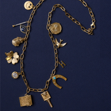 Heritage Chain with Smiley Face Charm, Divine Spark Matchstick, Sapphire Evil Eye, Oyster Vesta Case, Small Luck and Love Clover, Bezel Charm, Etched Vesta Case, Compass Key, Law of Attraction Magnet, Small Letter Charm, Bird Charm, and Amor Coin