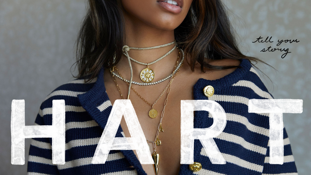 Model in Navy Striped sweater wearing necklace stack and HART logo plus Tell Your Story text overlay
